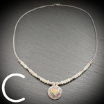 Sterling silver necklace with beads and an Aurora Opal style heart