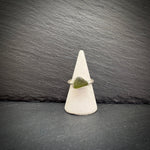Sea Glass Sterling Silver Ring with a green stone on a white cone against a dark slate background