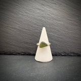 Sea Glass Sterling Silver Ring with a green stone on a white cone against a dark slate background